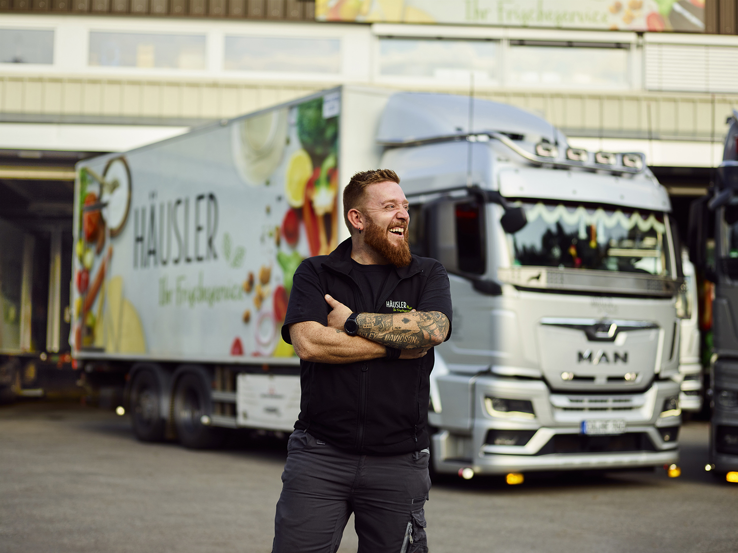 Beispiele für Teamfotos für die Personalsuche: KW Fahrer der vor seinem LKW posiert und dabei spaß hat